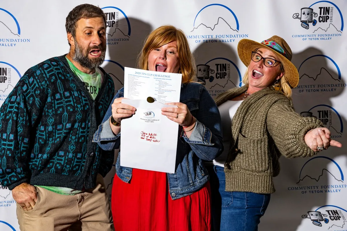 Three enthusiastic Tin Cup Challengers showing off their award certificate at the Community Foundation photo booth