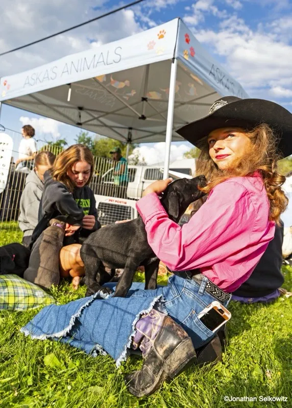 Young girl holding a puppy at a Teton Valley nonprofit community event