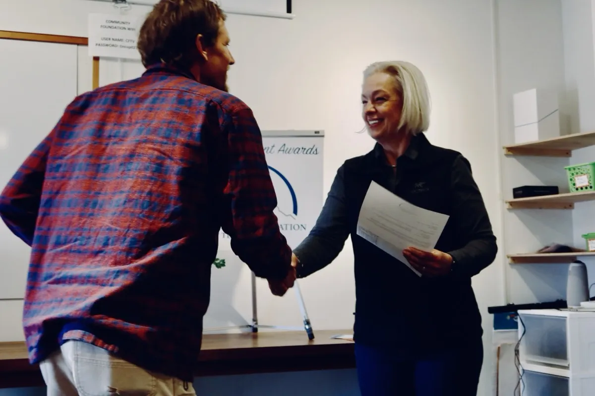 Community Foundation representative shaking hands with a grant recipient at an awards ceremony
