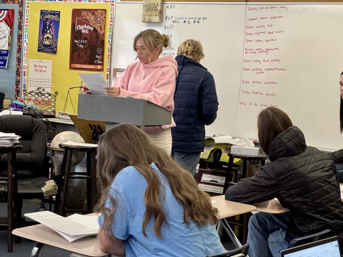Youth Philanthropy students presenting nonprofit research in a classroom with whiteboard notes